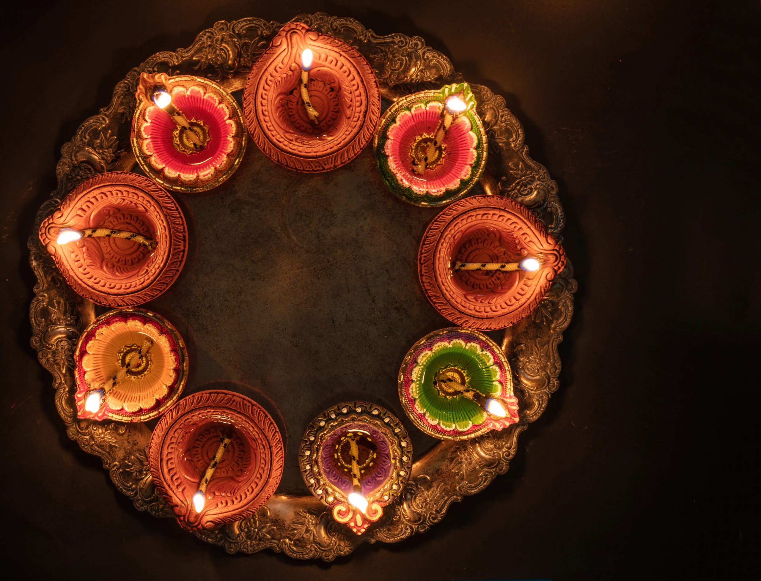 Diwali, Deepavali. Hindu Festival of lights celebration, India. Diya oil lamp Deepavali Diwali, Hindu Festival of lights celebration. Diya oil lamp lit on traditional Puja thali, top view.