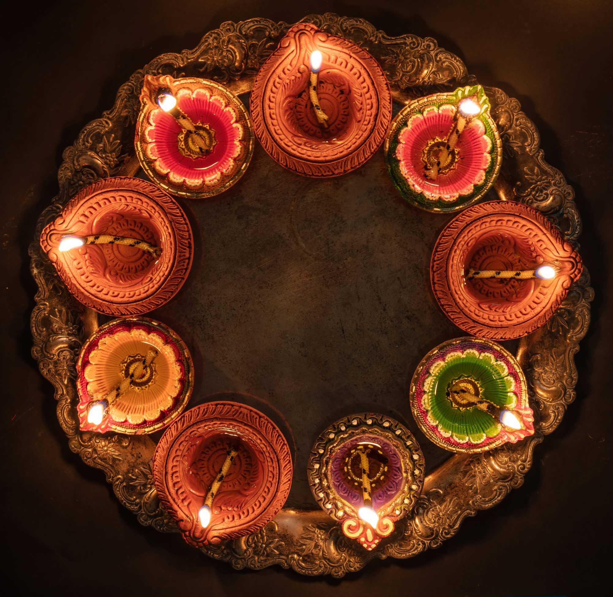Diwali, Deepavali. Hindu Festival of lights celebration, India. Diya oil lamp Deepavali Diwali, Hindu Festival of lights celebration. Diya oil lamp lit on traditional Puja thali, top view.