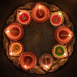 Deepavali Diwali, Hindu Festival of lights celebration. Diya oil lamp lit on traditional Puja thali, top view.