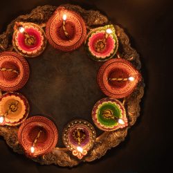 Deepavali Diwali, Hindu Festival of lights celebration. Diya oil lamp lit on traditional Puja thali, top view.