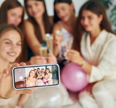 Holding glasses with drink. Group of happy women that is at a bachelorette party.